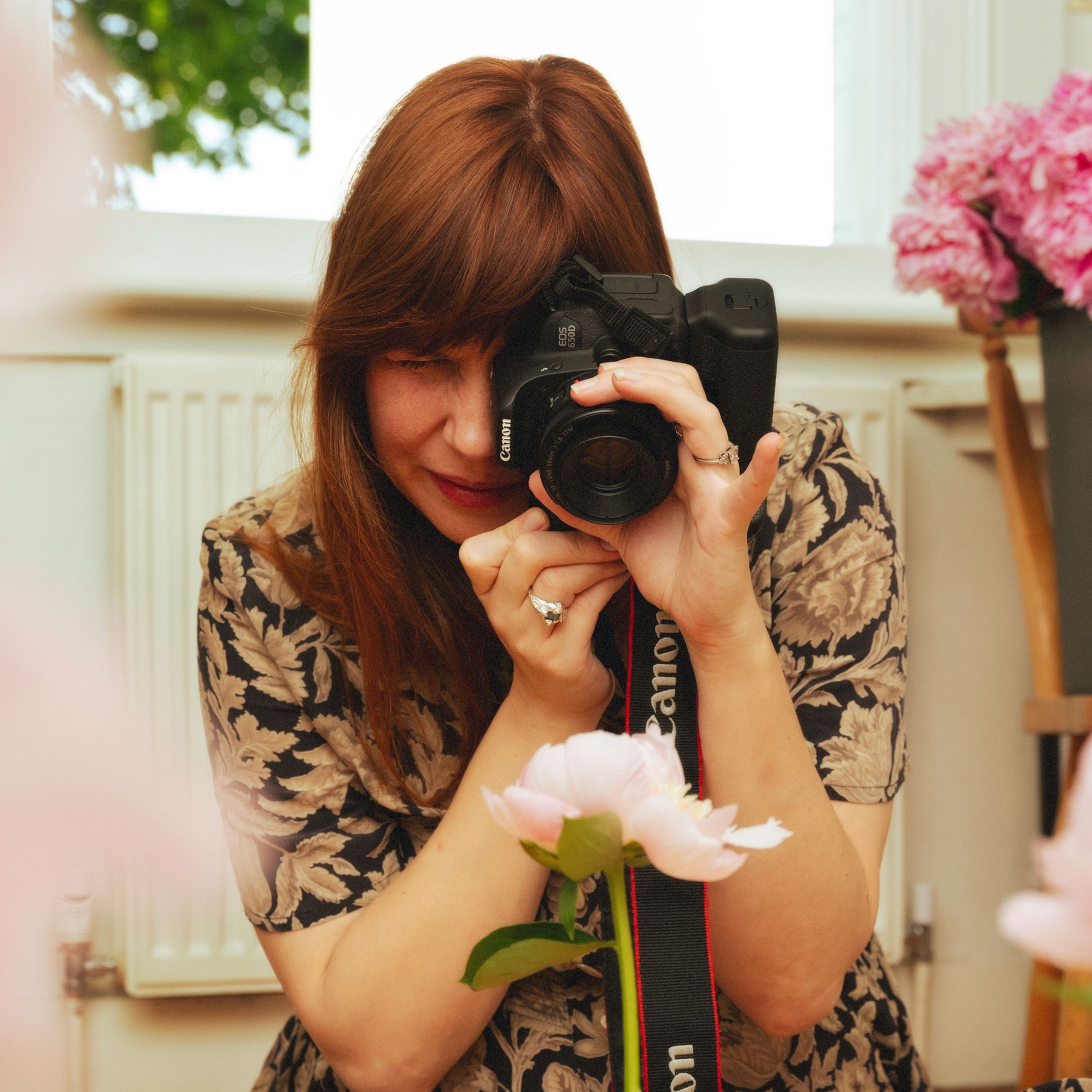 Anna Ridler taking a photo of a flower in her studio