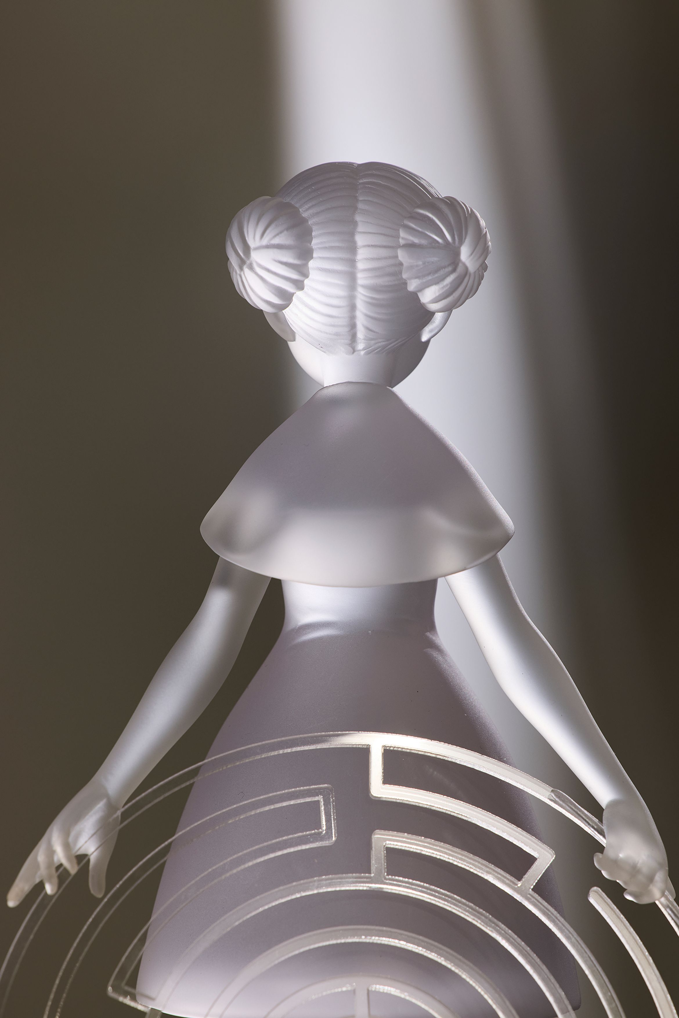 light filled sculpture of a girl holding a circular maze