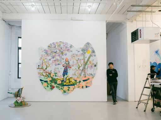 Tomokazu Matsuyama leaning against the wall next to a large painting Tomokazu Matsuyama leaning against the wall next to a large painting