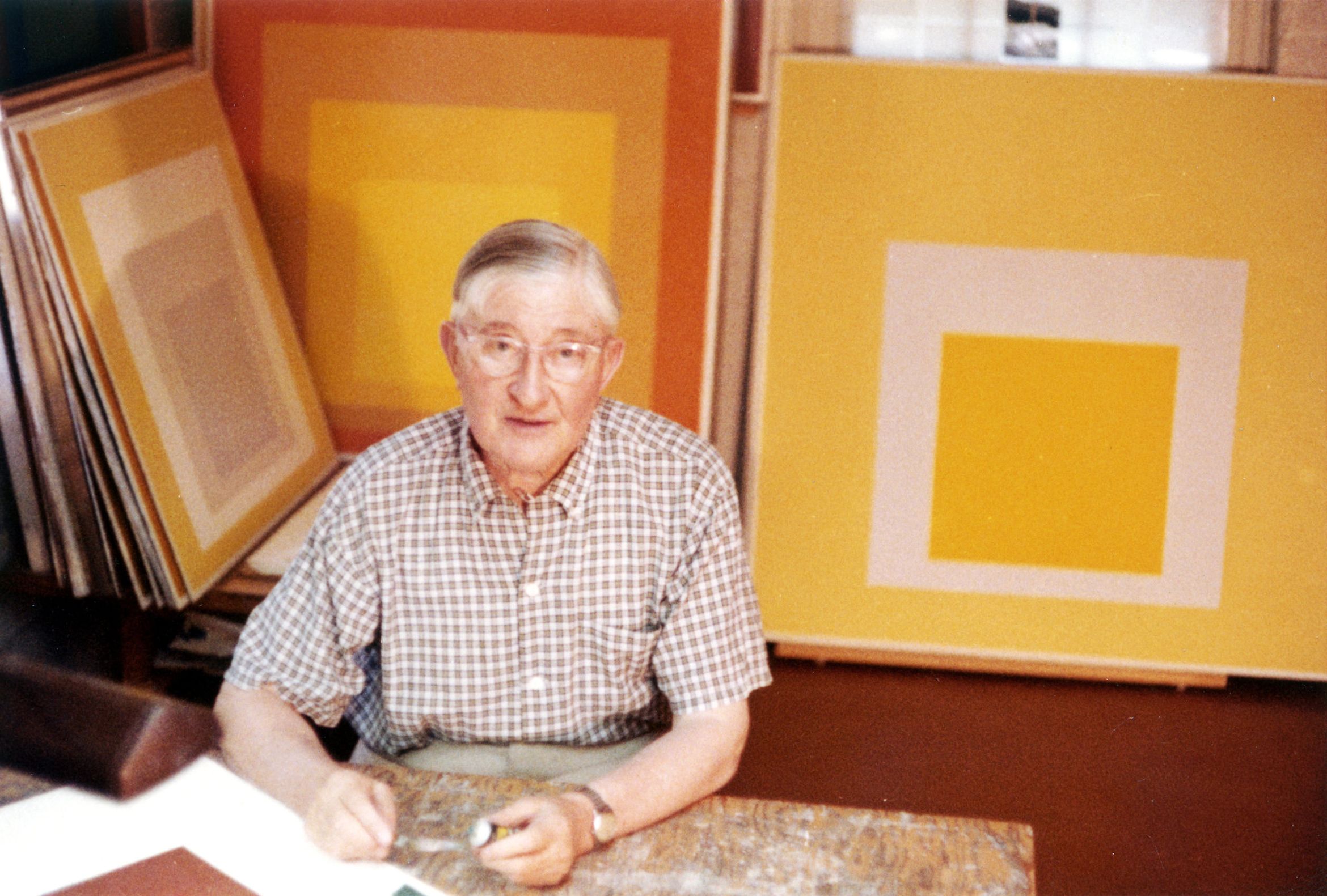 Man sitting in front of yellow canvases