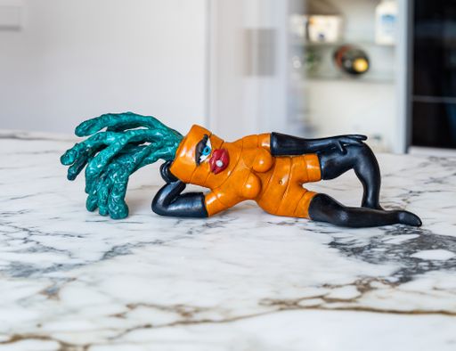 painted bronze carrot reclining seductively on a white marble countertop painted bronze carrot reclining seductively on a white marble countertop