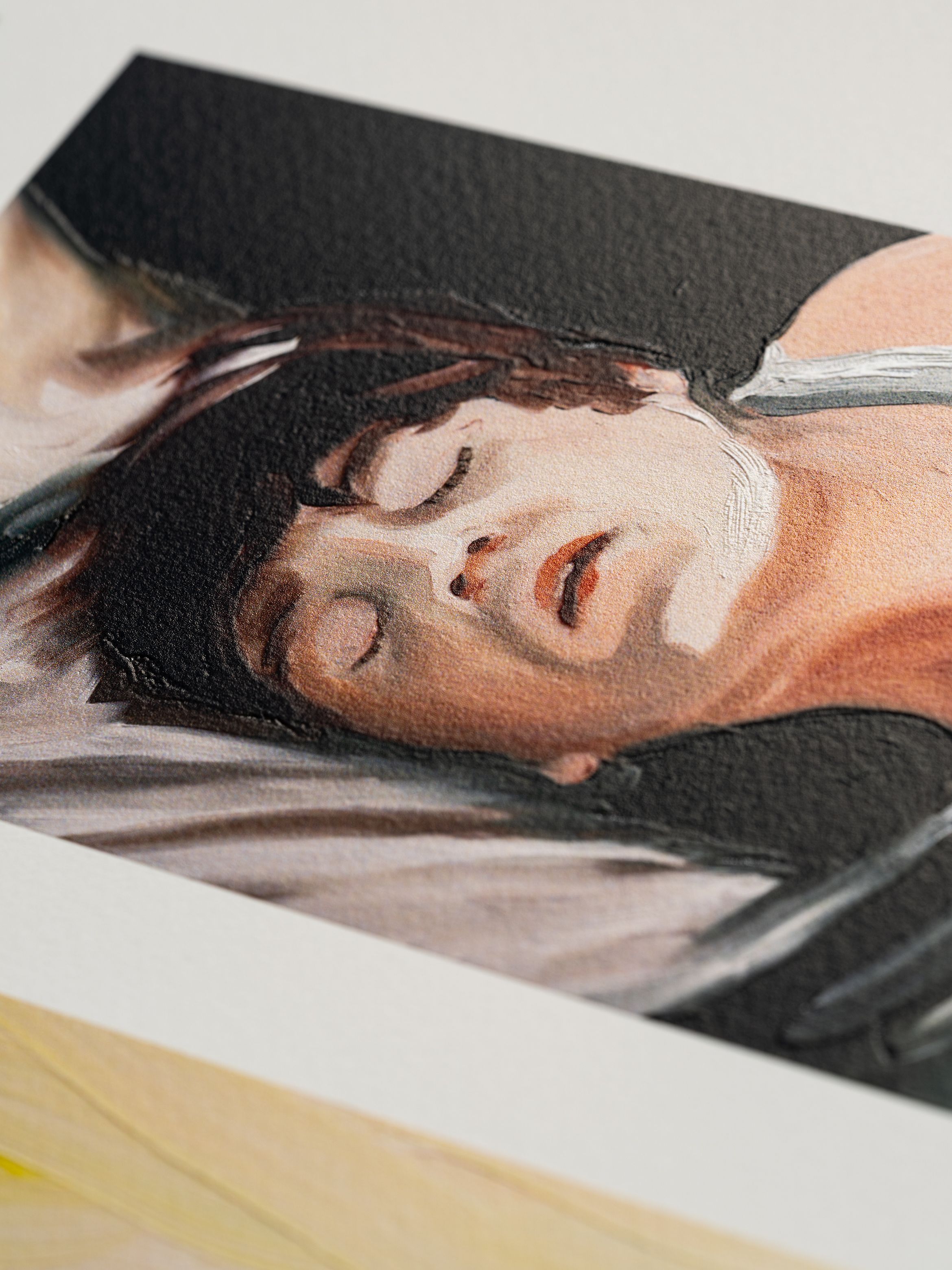 A detailed painting of a person sleeping peacefully, with closed eyes and short hair, displayed on textured white paper.