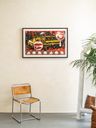 a framed print edition by Jaime Munoz photographed hung on a white wall above a chair a framed print edition by Jaime Munoz photographed hung on a white wall above a chair