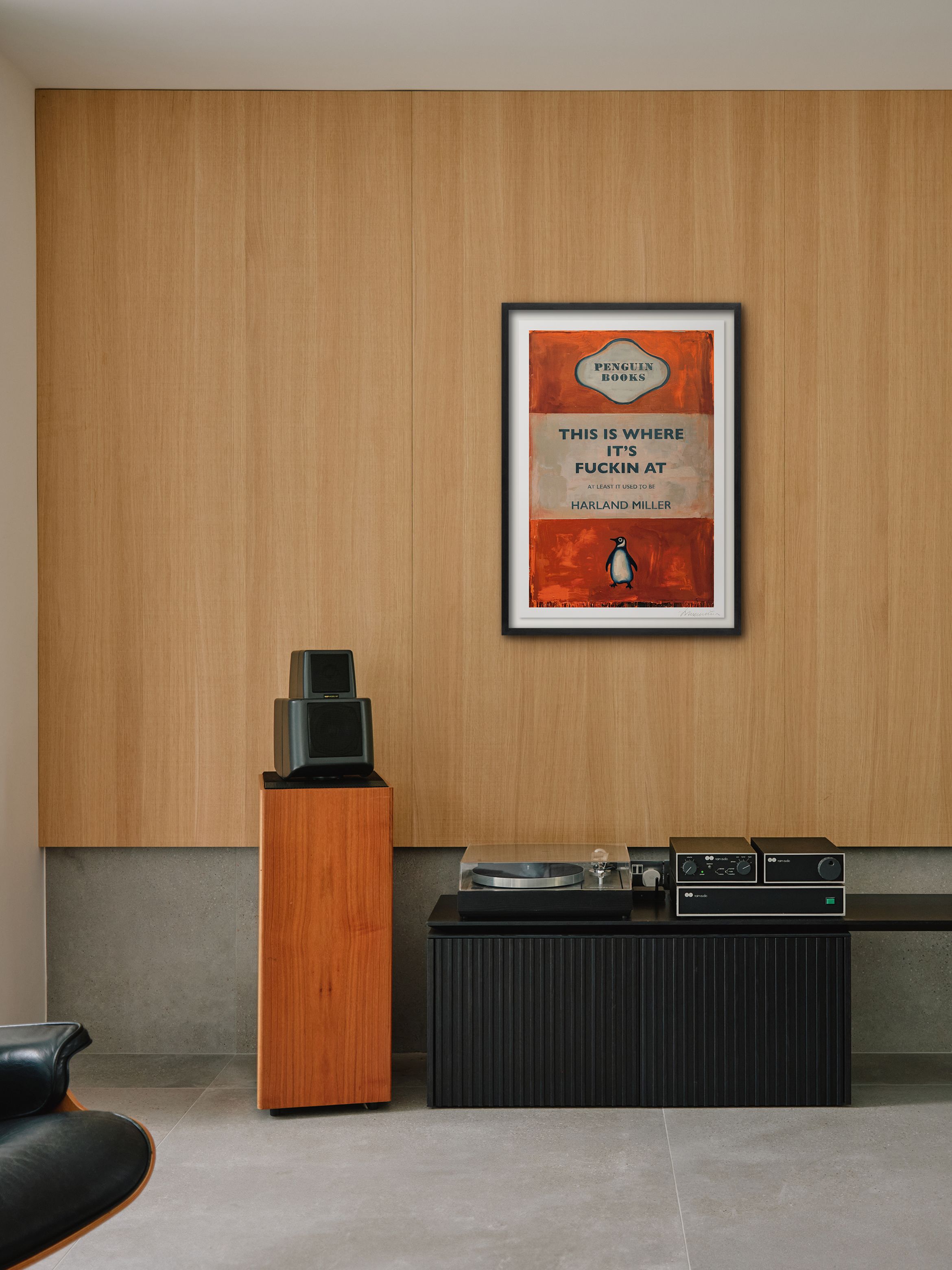 Hero of a silkscreen print in black frame on wood wall by Harland Miller.