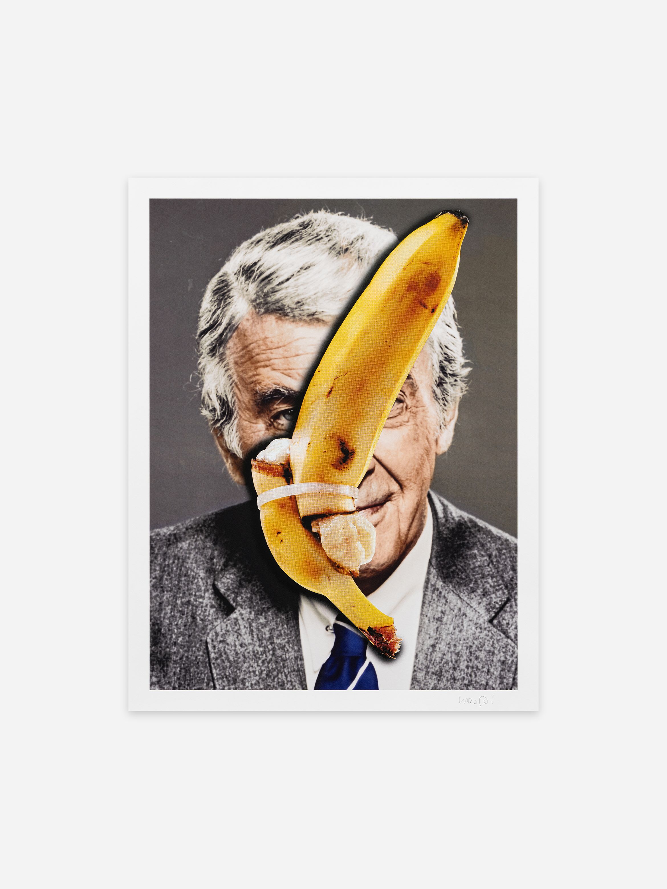 Portrait of an older man in a suit partially covered by a bruised banana placed over his face against a plain background.