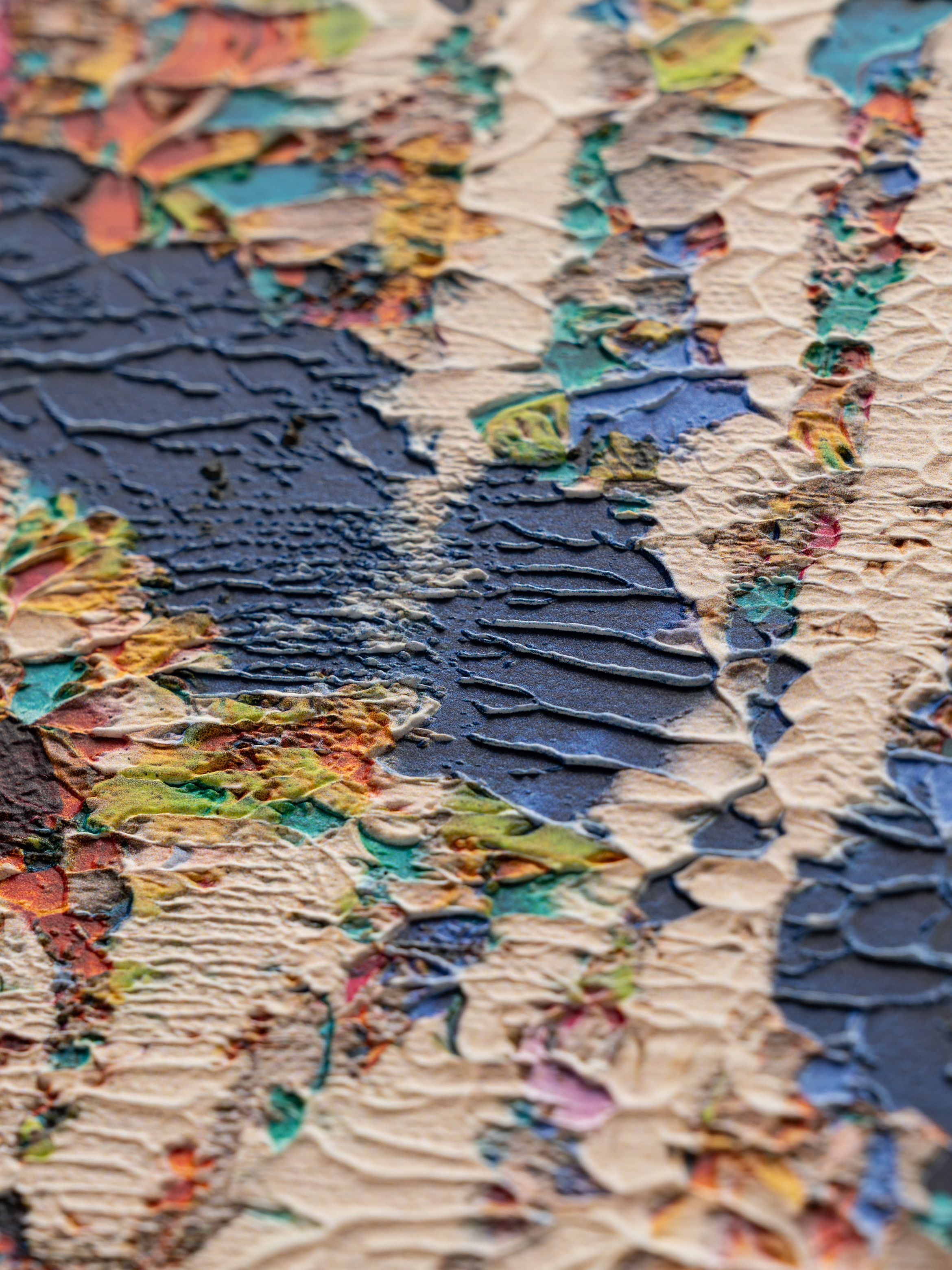 Close-up of a textured abstract painting with layered strokes in blue, beige, and multicoloured accents, creating a dynamic surface relief.