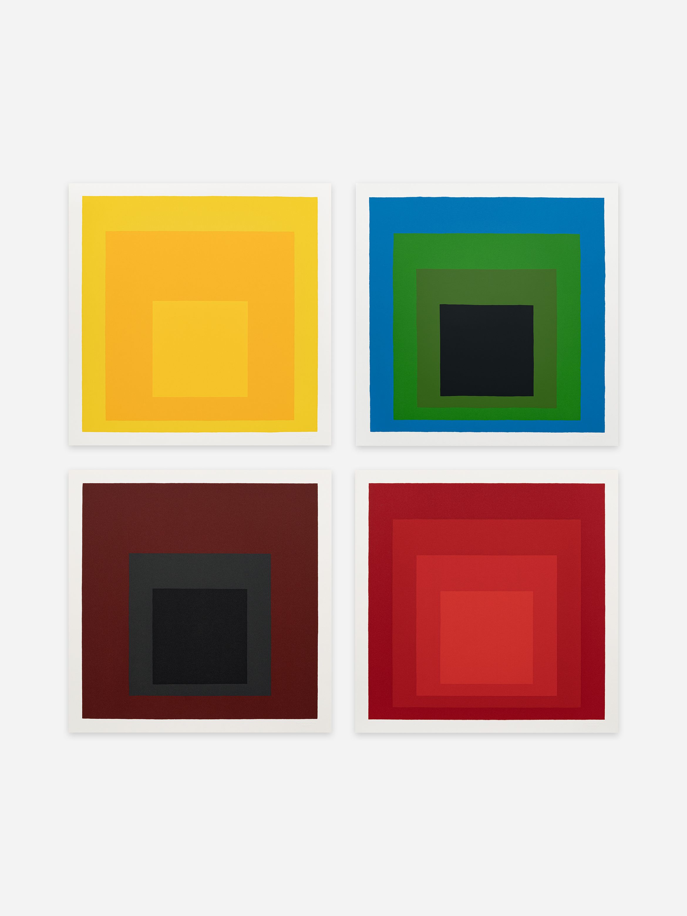 Four abstract artworks of squares in varying colours: yellow, blue and green, brown, and red, arranged in a two-by-two grid.