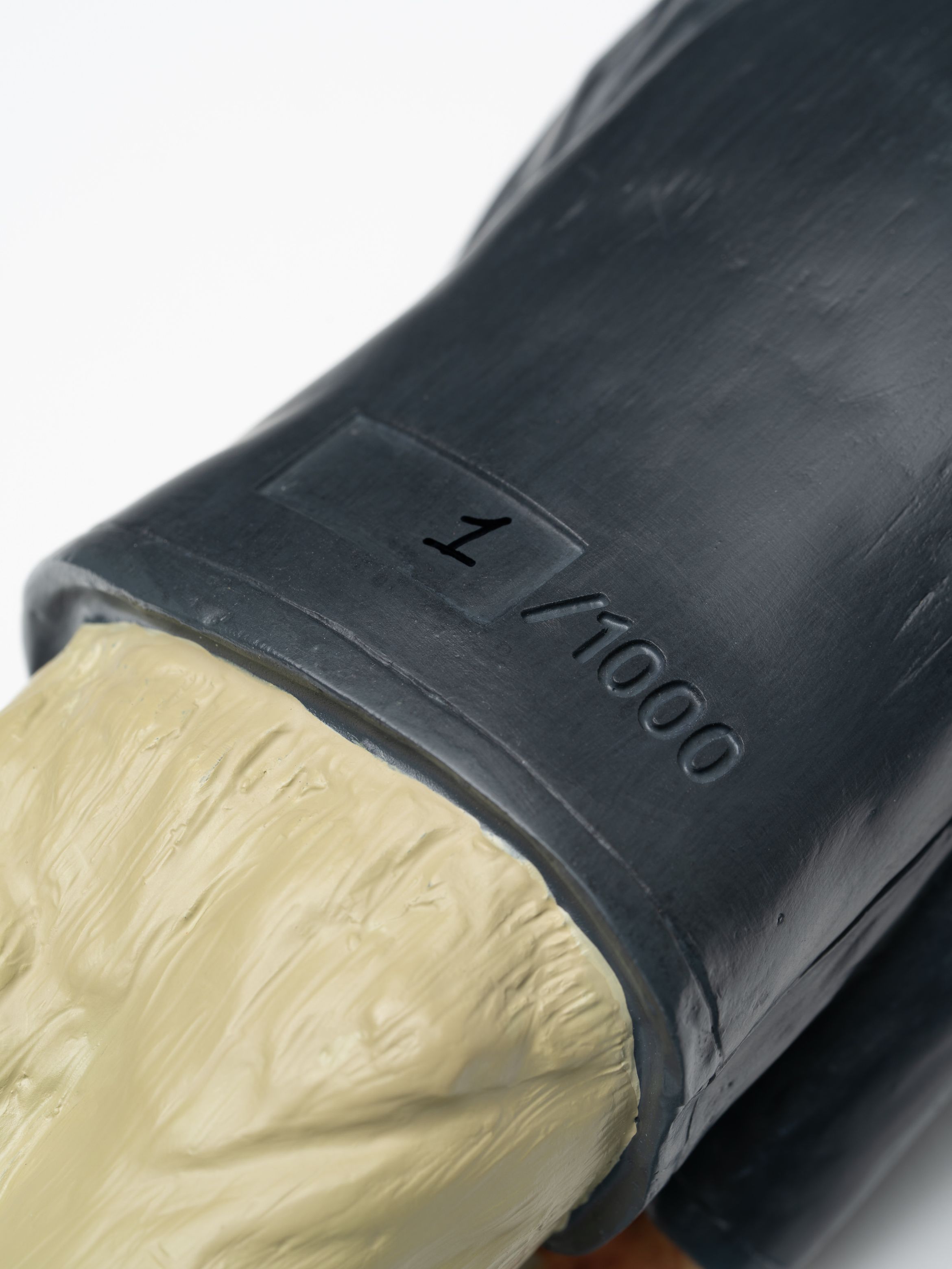Close-up of a collectible figure's base, showing "1/1000" engraved, indicating it is the first in a limited edition series.