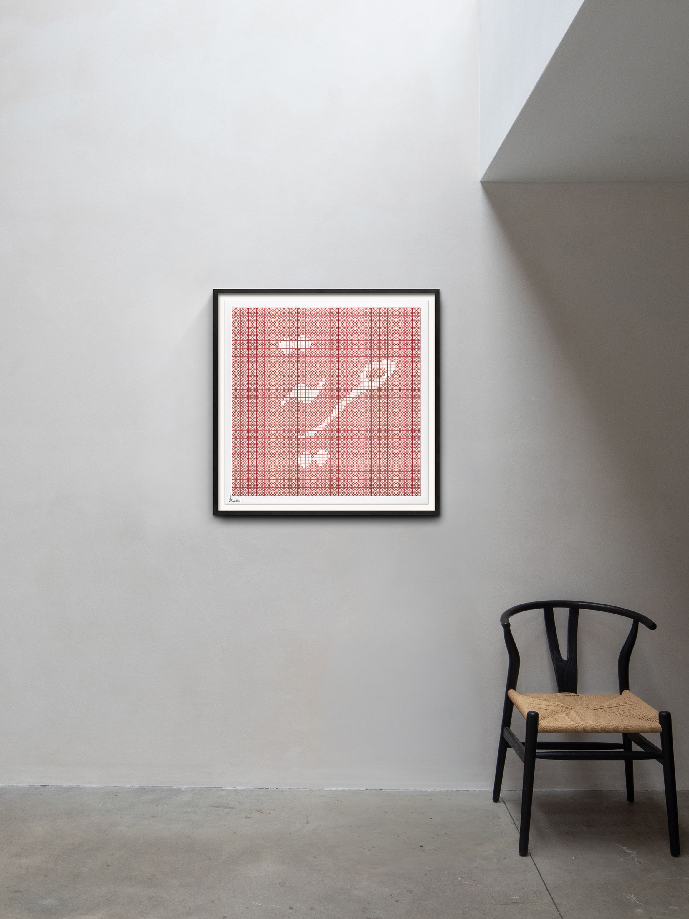 Framed red grid artwork on a light gray wall, accompanied by a wooden chair with a woven seat on a concrete floor.