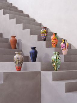 seven hand-painted amphorae arranged on a grey staircase seven hand-painted amphorae arranged on a grey staircase