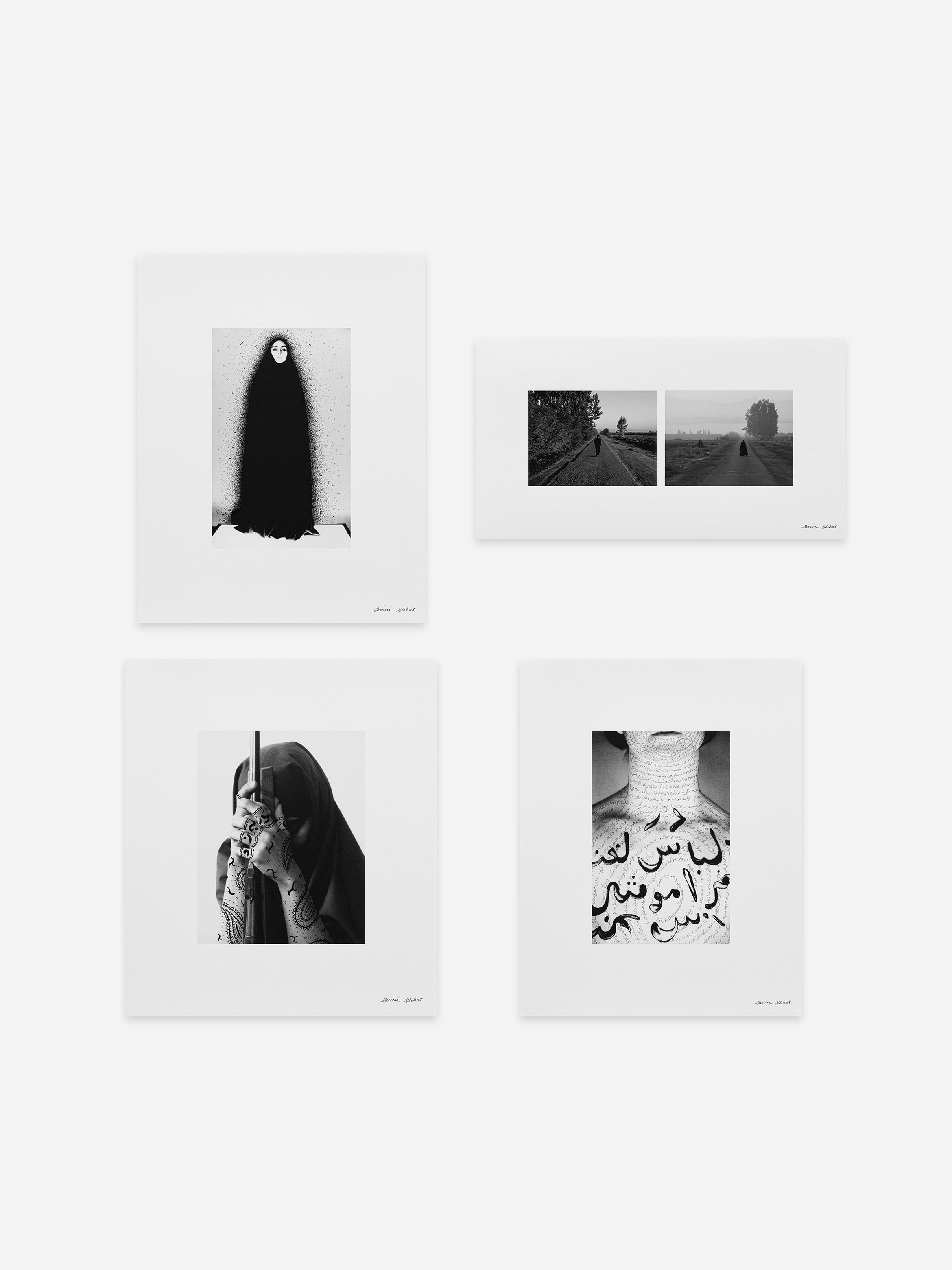 Four framed black and white photographs on a wall, featuring landscapes, a person in traditional attire, and abstract designs.