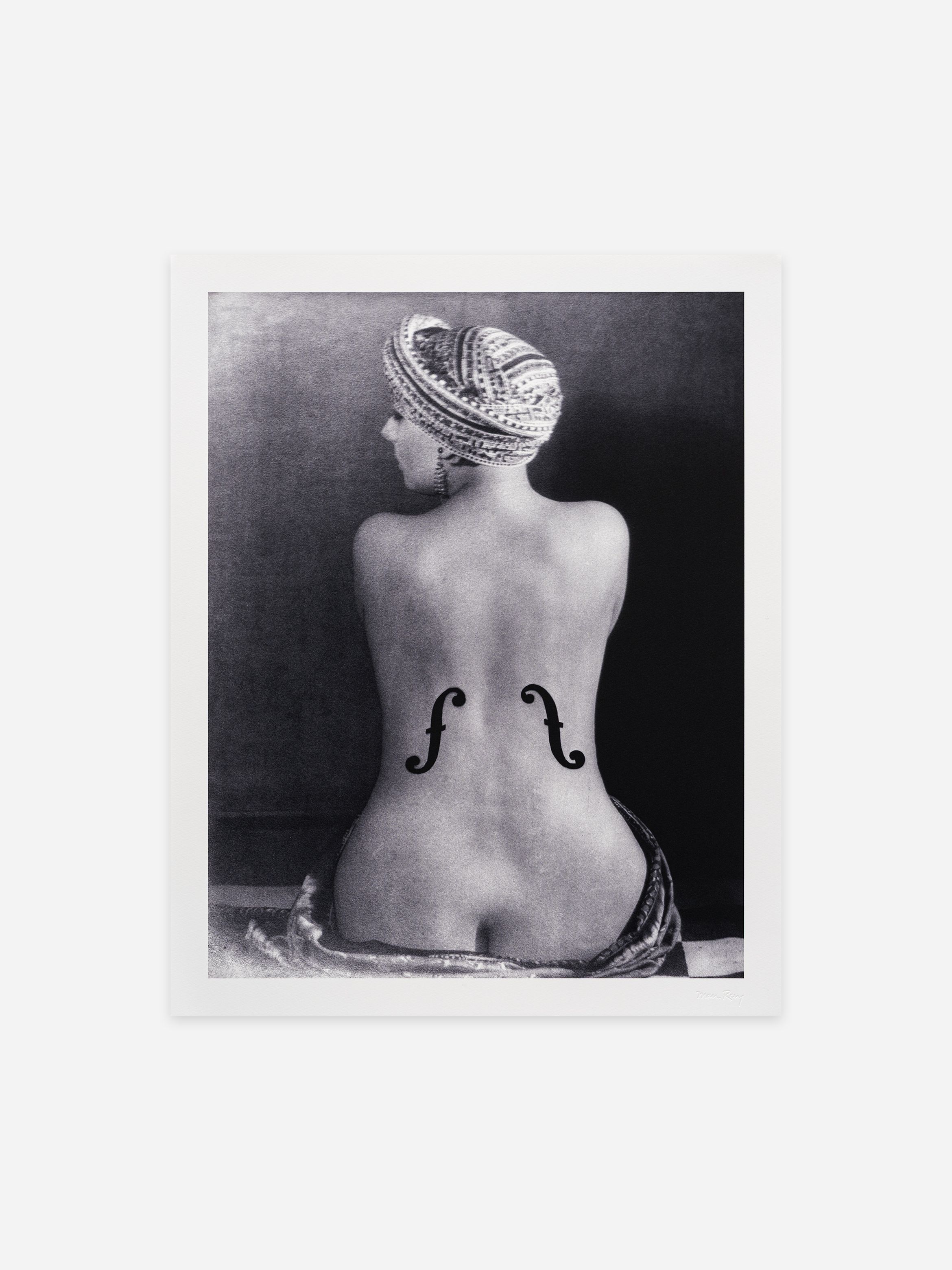 Black and white photo of a woman with a turban, her back to the camera, featuring two f-holes like a violin on her lower back.