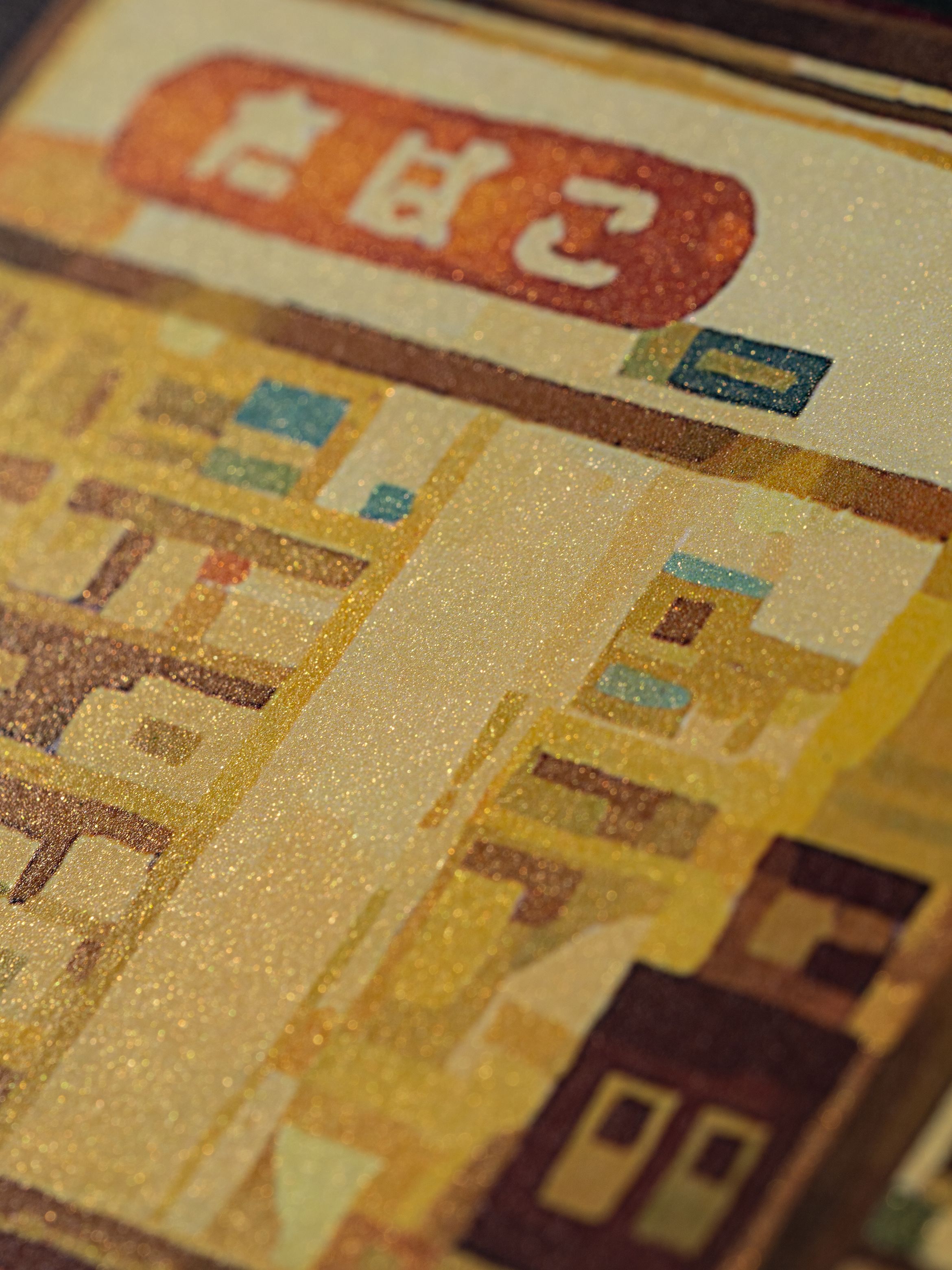 Close-up of a colorful, abstract depiction of a building with a red sign at the top, featuring a textured, glittery surface.