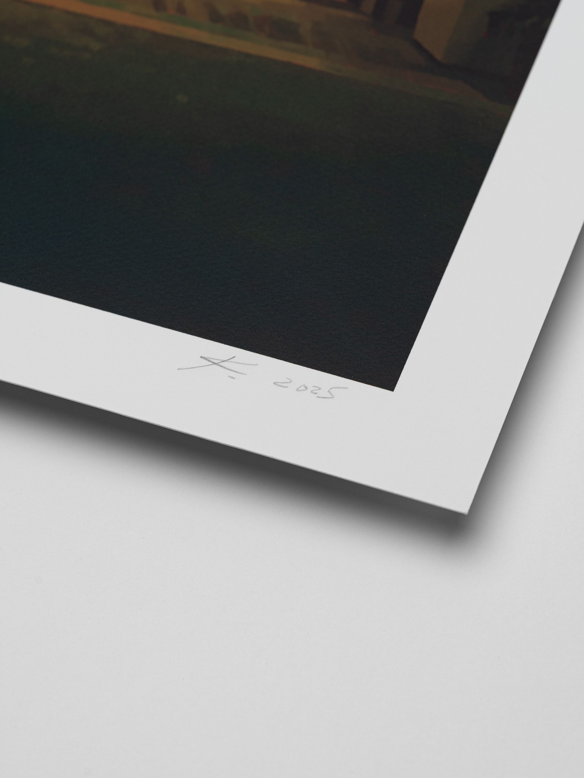 Close-up of a signed and dated print corner, showing a white border with a signature and "2025" written in pencil on a dark background.