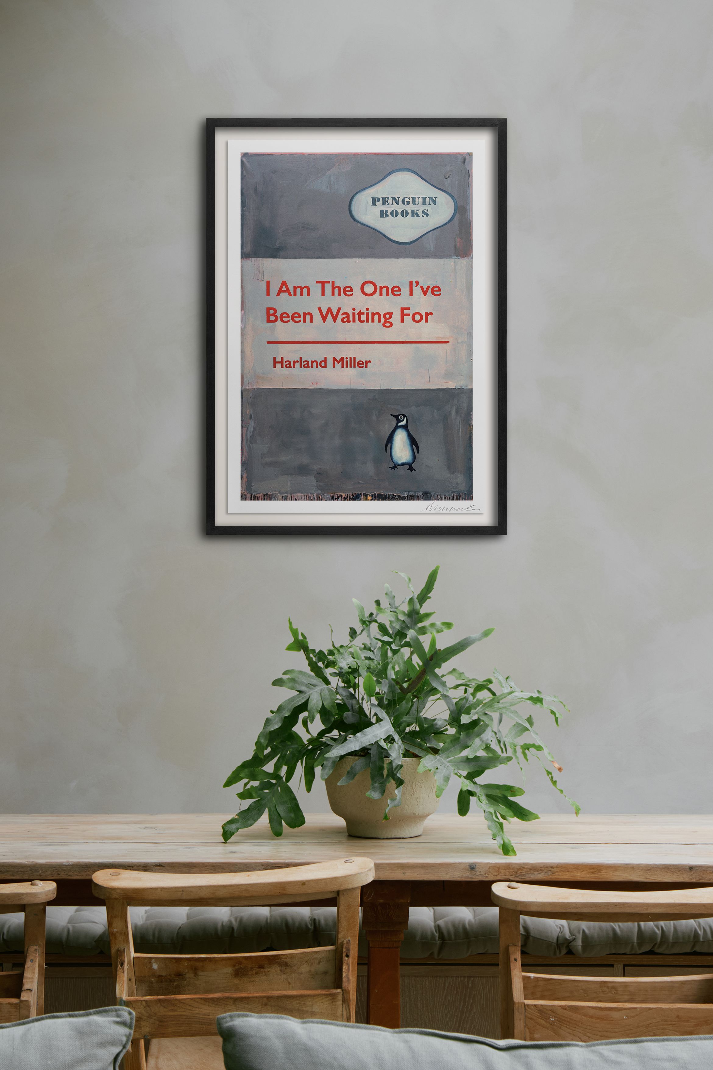 Hero of a silkscreen print in black frame on grey wall by Harland Miller.