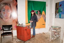 female artist working in a studio on a painting female artist working in a studio on a painting