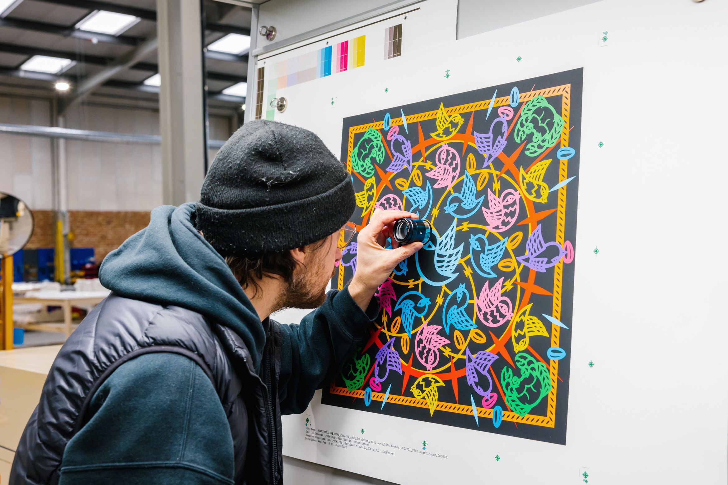 printmaker inspecting the surface of a print using a magnifying glass