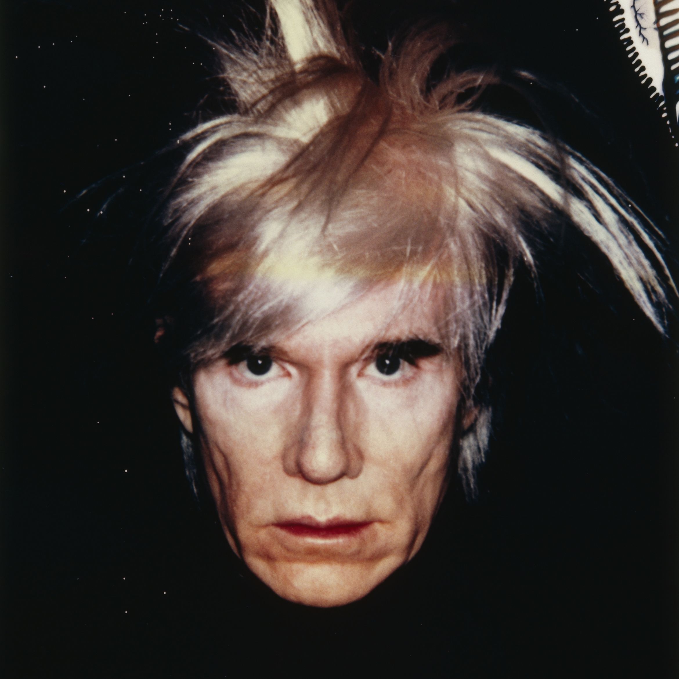 Andy Warhol with a pale face and disheveled blonde hair, staring directly at the camera against a dark background. Andy Warhol with a pale face and disheveled blonde hair, staring directly at the camera against a dark background.