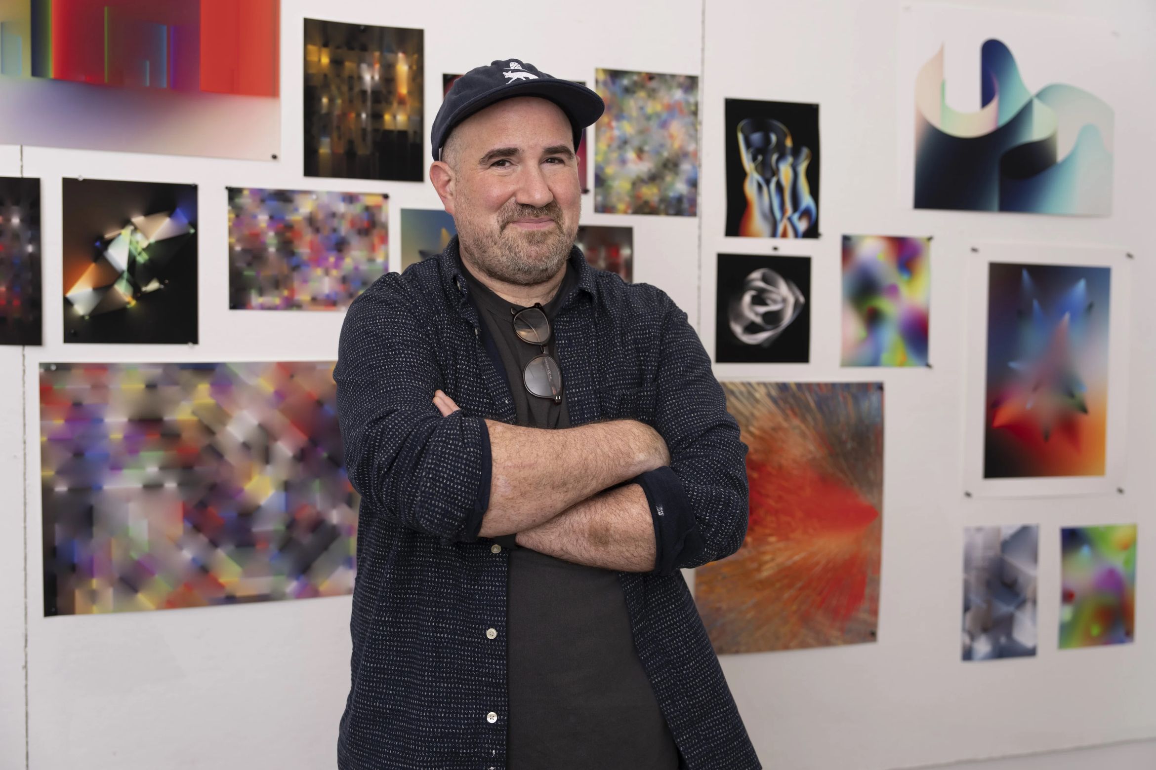 Portrait of artist Zach Lieberman standing in front of his work with his arms crossed