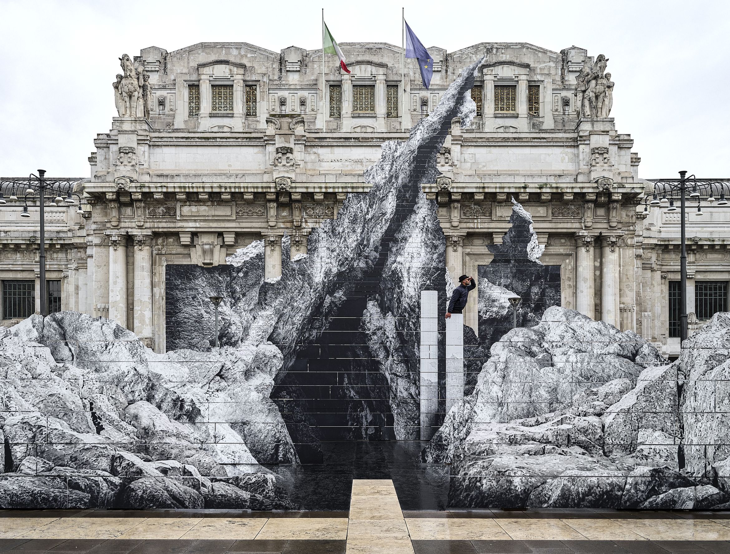 JR stands within La Nascita sculpture at Milano Centrale