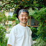 Yu Nagaba standing in a garden outside his studio smiling Yu Nagaba standing in a garden outside his studio smiling