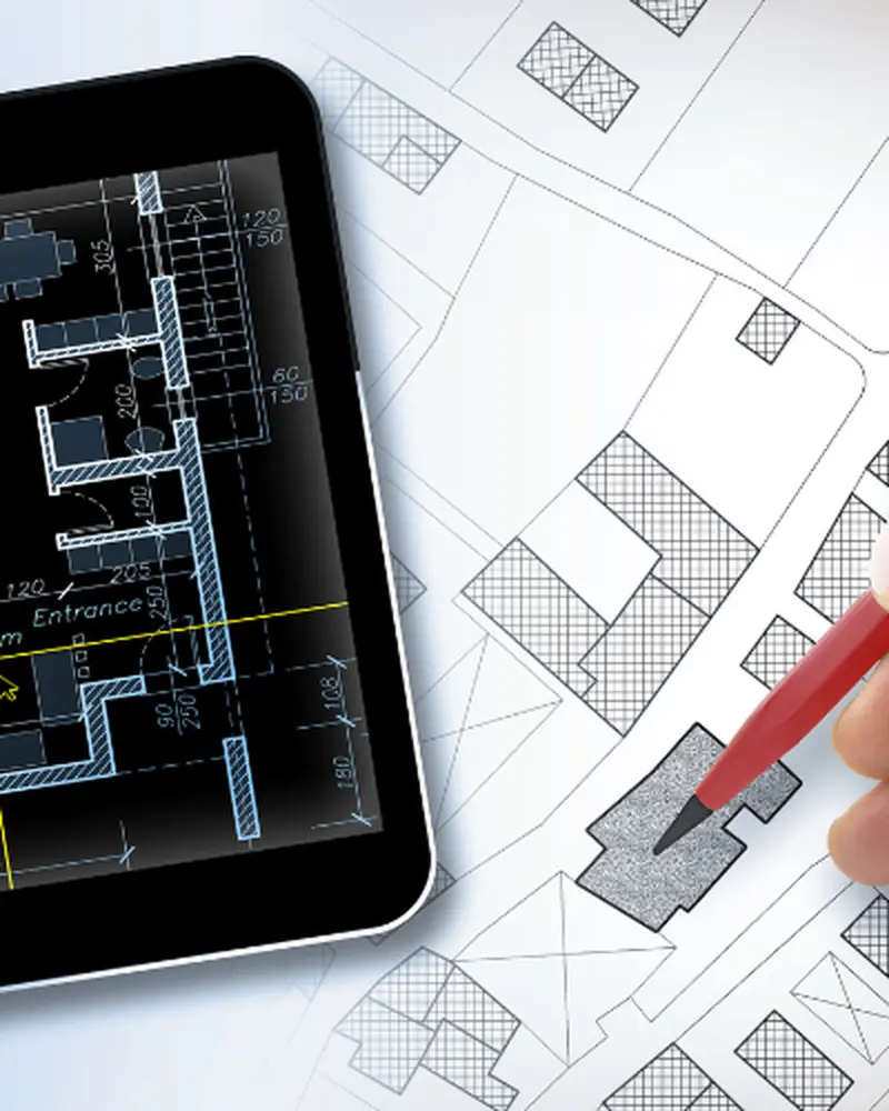 Tablet displaying digital floor plan next to a hand drawing on architectural blueprints with a red pencil.