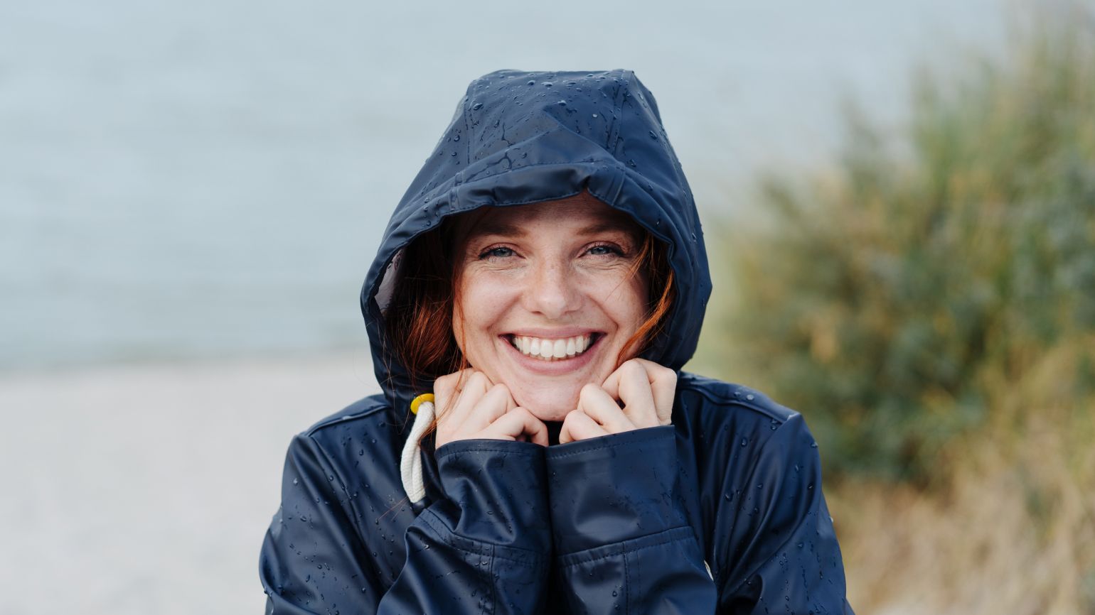 Fröhliche Frau in schlechtem Wetter