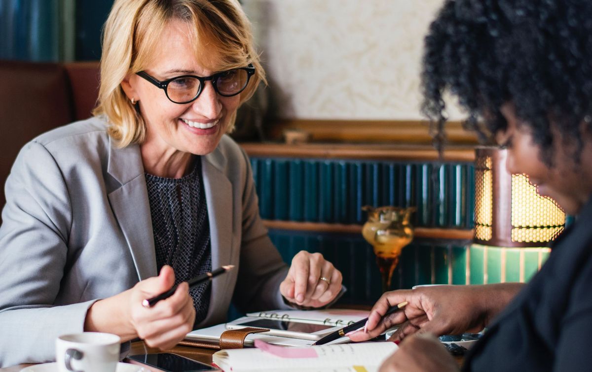Two women having coffee and looking over finances