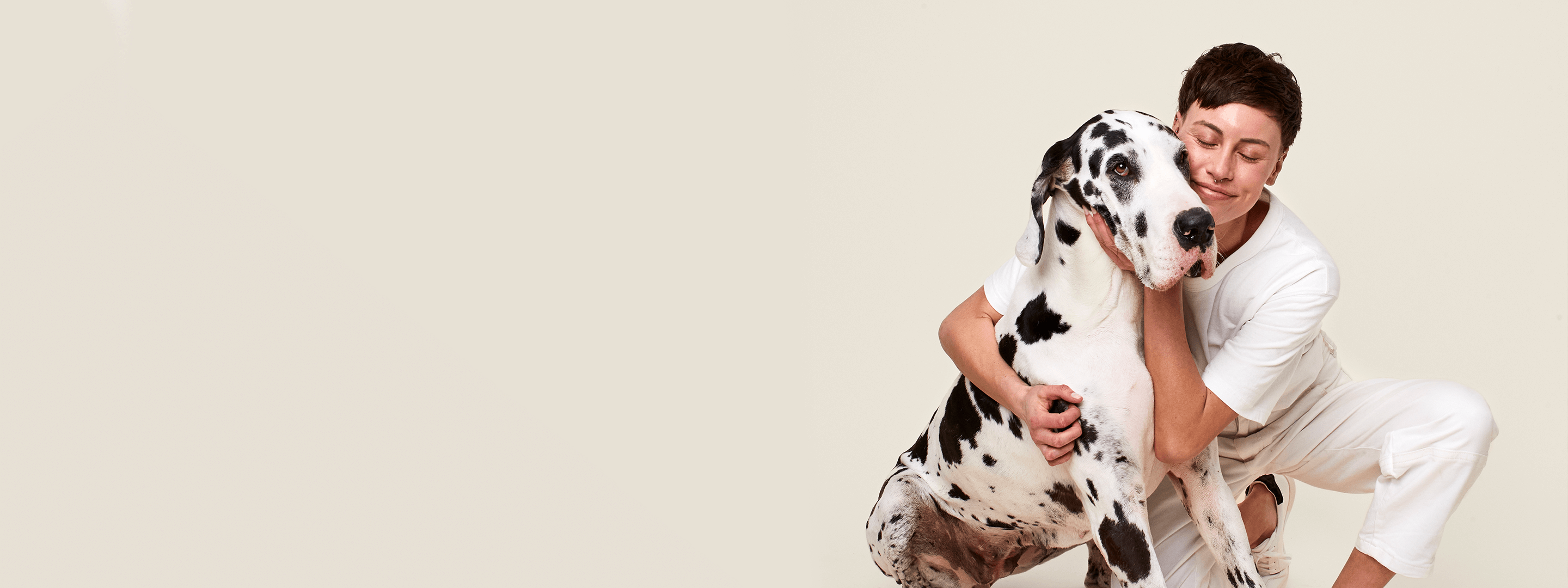 An owner happily hugging her dog.