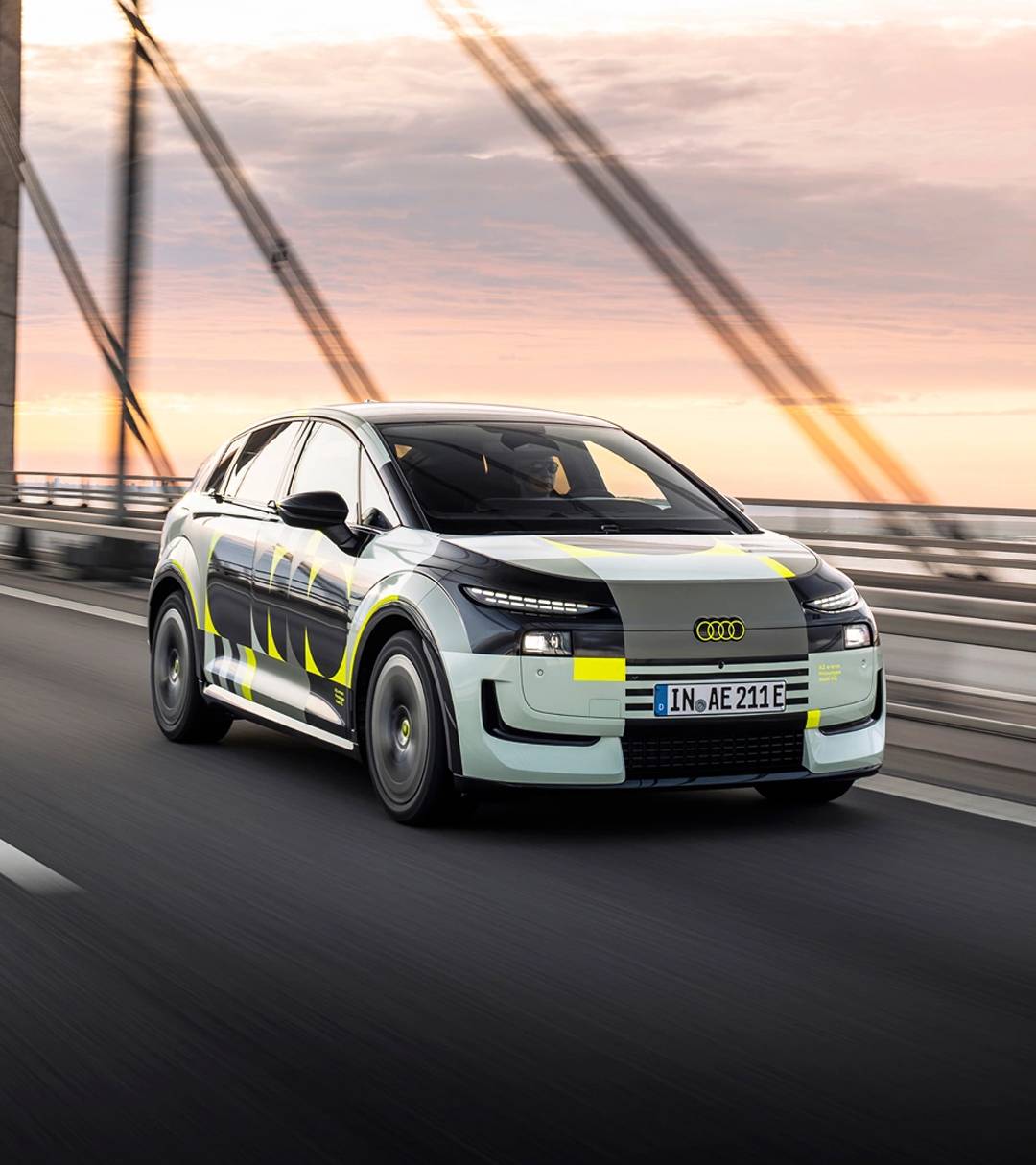 The front of the Audi A2 e-tron driving across a bridge