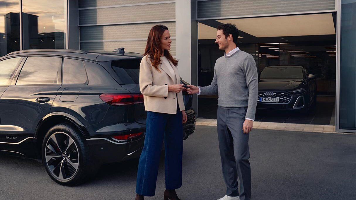A man handing over keys to a woman