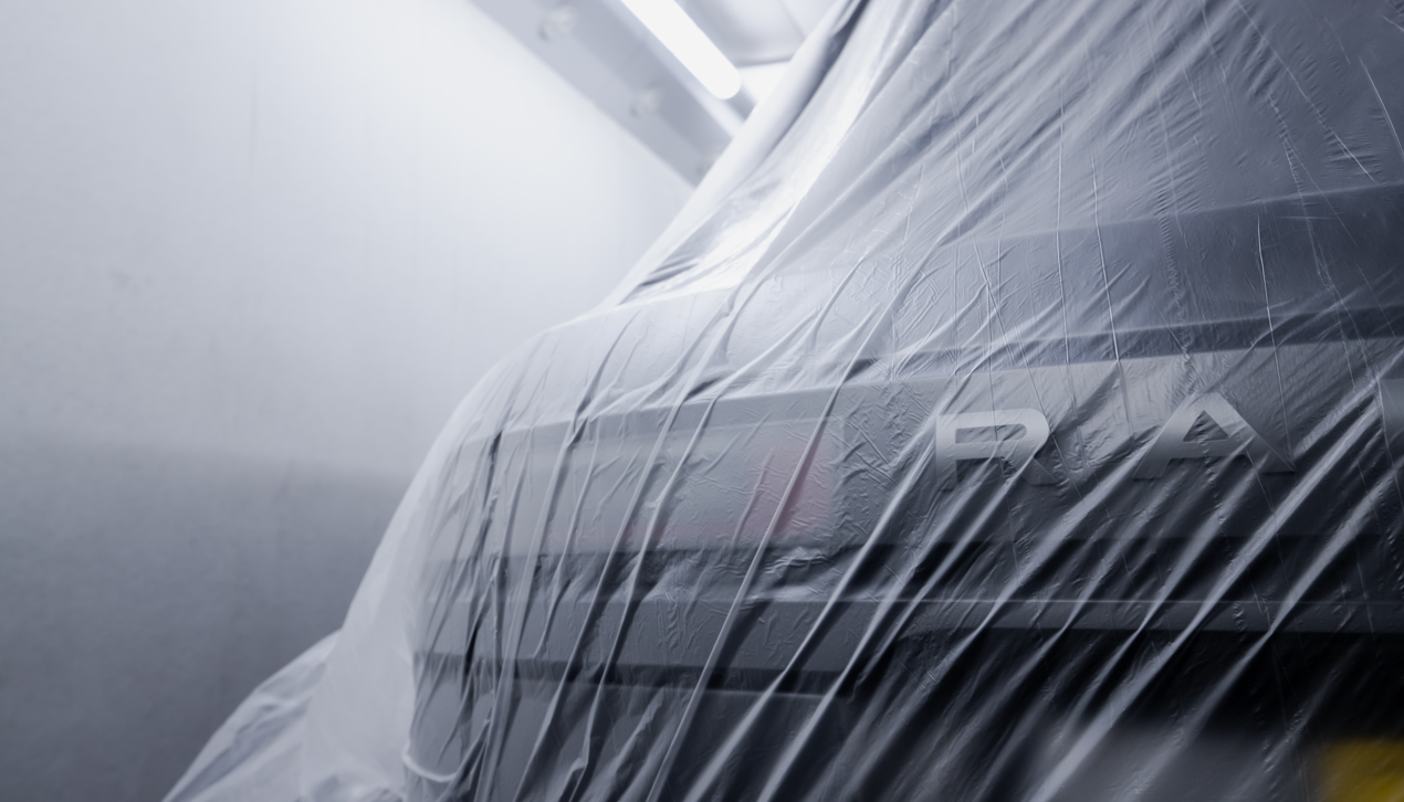 Close up of a Range Rover covered with a clear sheet.