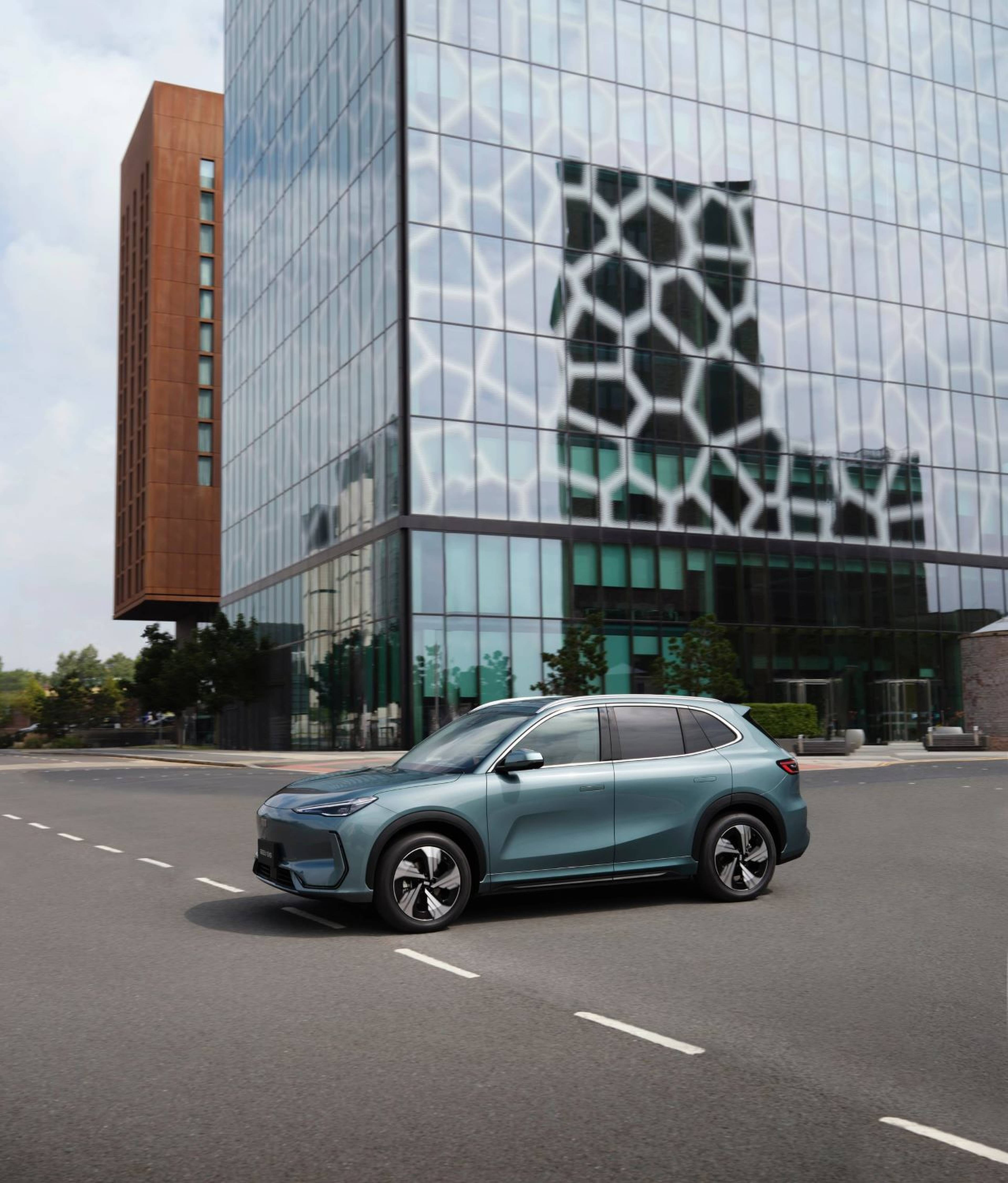 Geely EX5 Max in Jade Green parked on a road in front of a modern glass building.