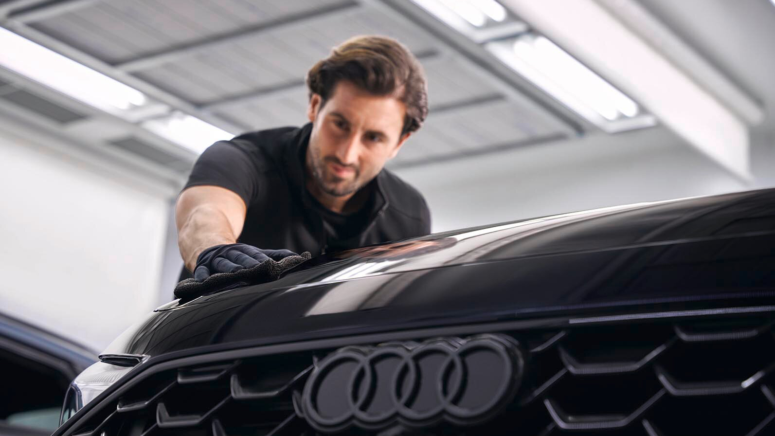 A man wiping down a Audi bonnet