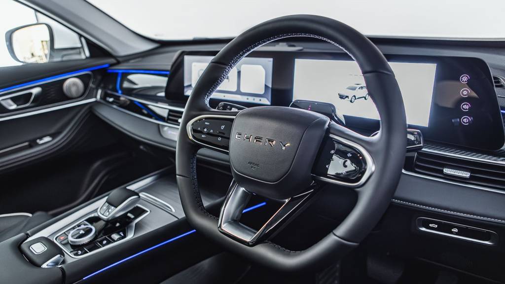 Front driver and passenger area of the Chery TIGGO 7 showing the steering wheel and centre console, finished in black