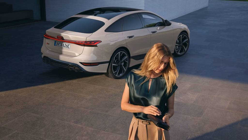A woman shutting her purse in the foreground and an Audi A6 Saloon in the background