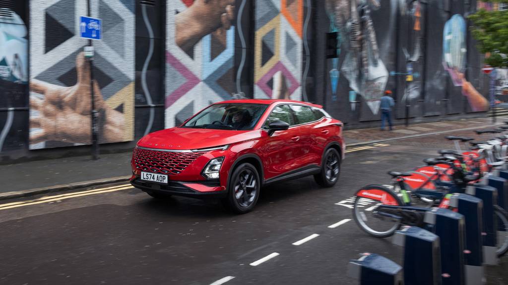 Red OMODA driving through a street