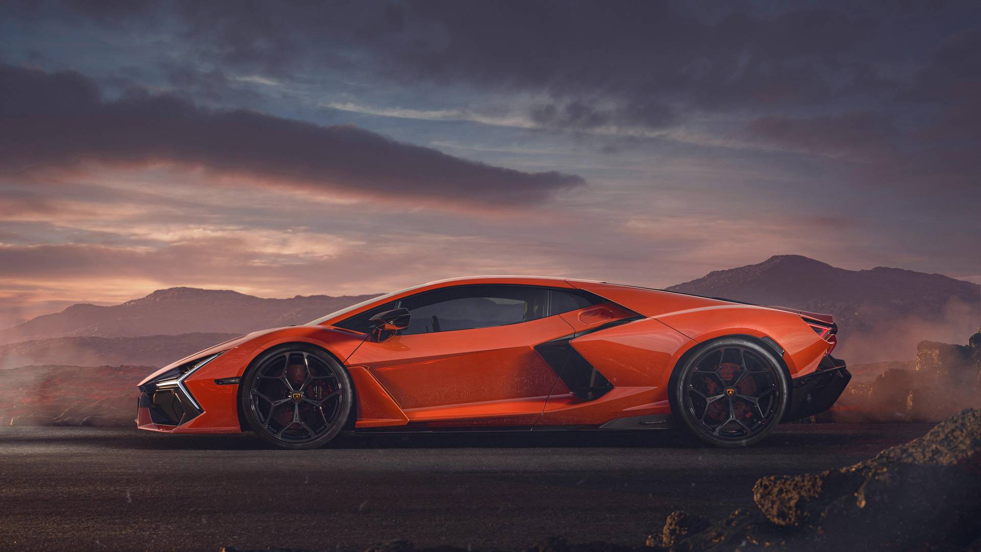 The Lamborghini Revuelto side profile in orange at dusk