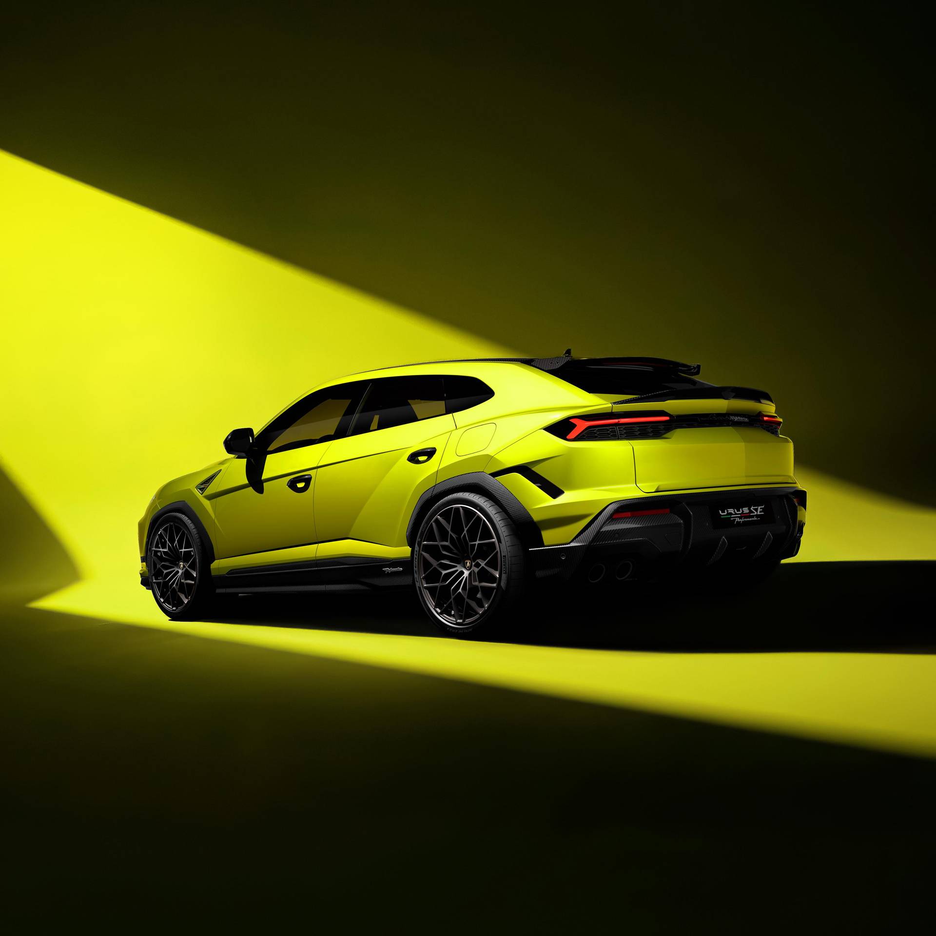 Urus Performante SE in yellow on a yellow back drop with contrasting shadows, back 3/4 image