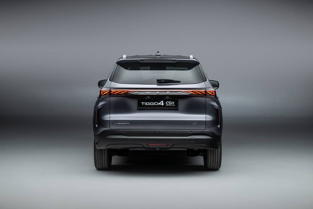 CHERY TIGGO 4 Super Hybrid rear end, in a grey metallic colour with the rear lights on. Parked in a studio with a grey gradient background