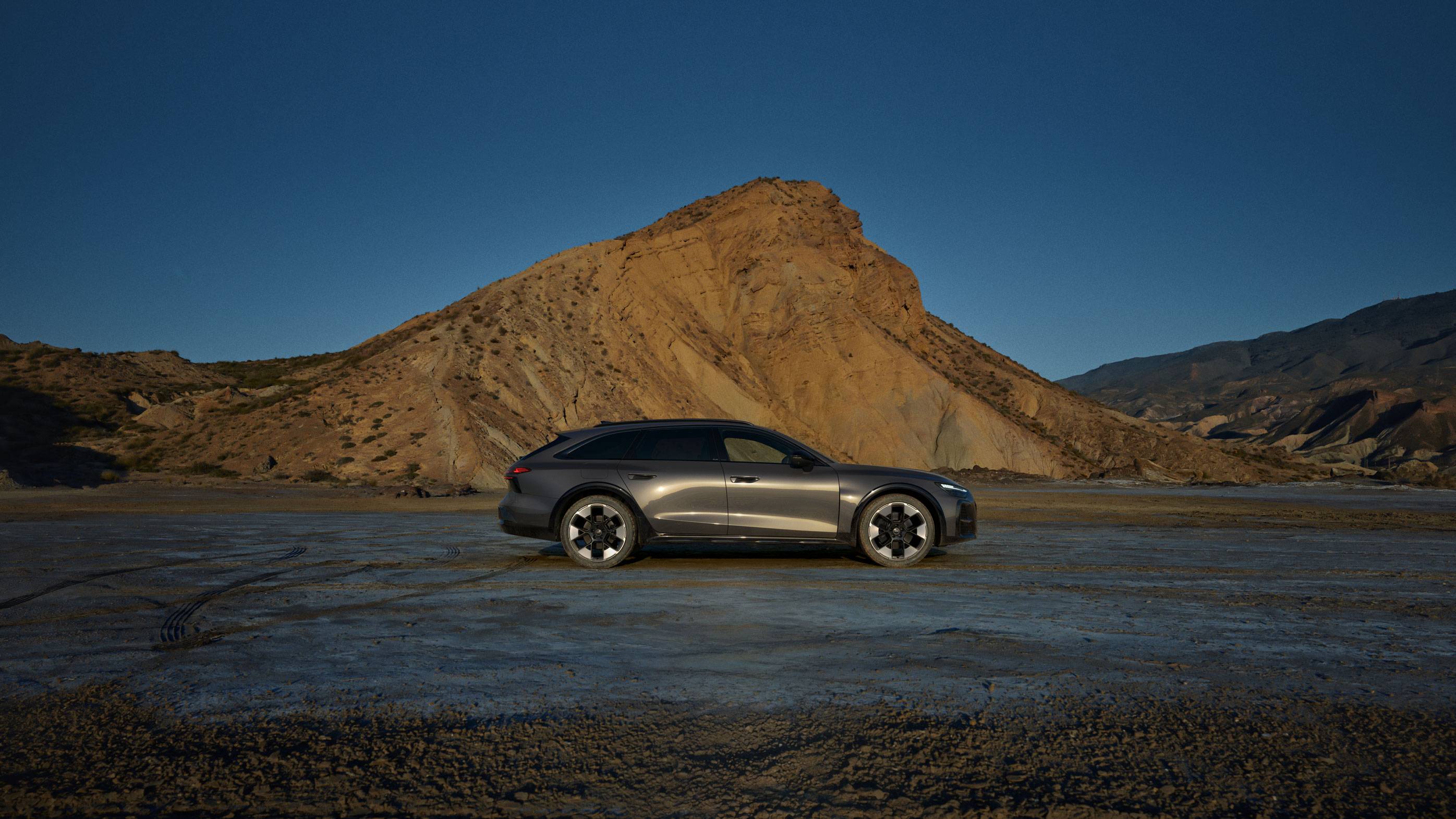 Audi A6 allroad side on, in front of a yellow mountain