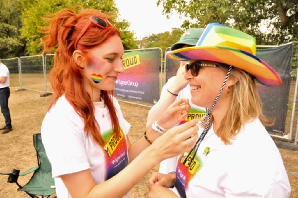 Someone assisting another person to tie their hat at Leicester Pride 2025