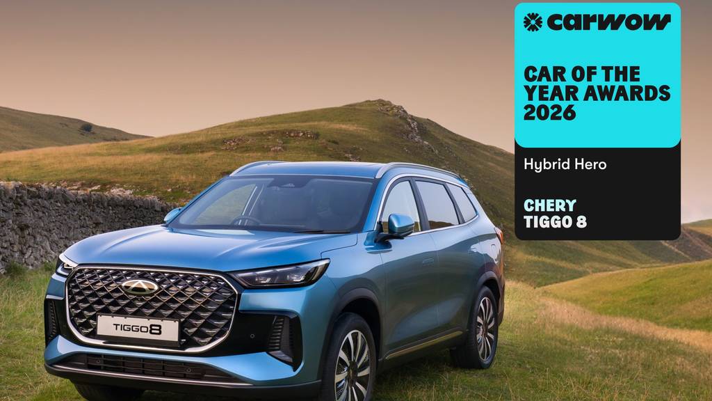 a blue TIGGO 8 parked on a grassy hill with a stone brick wall to the left. With a banner for Carwow Car of the year 2026 as their Hybrid Hero.