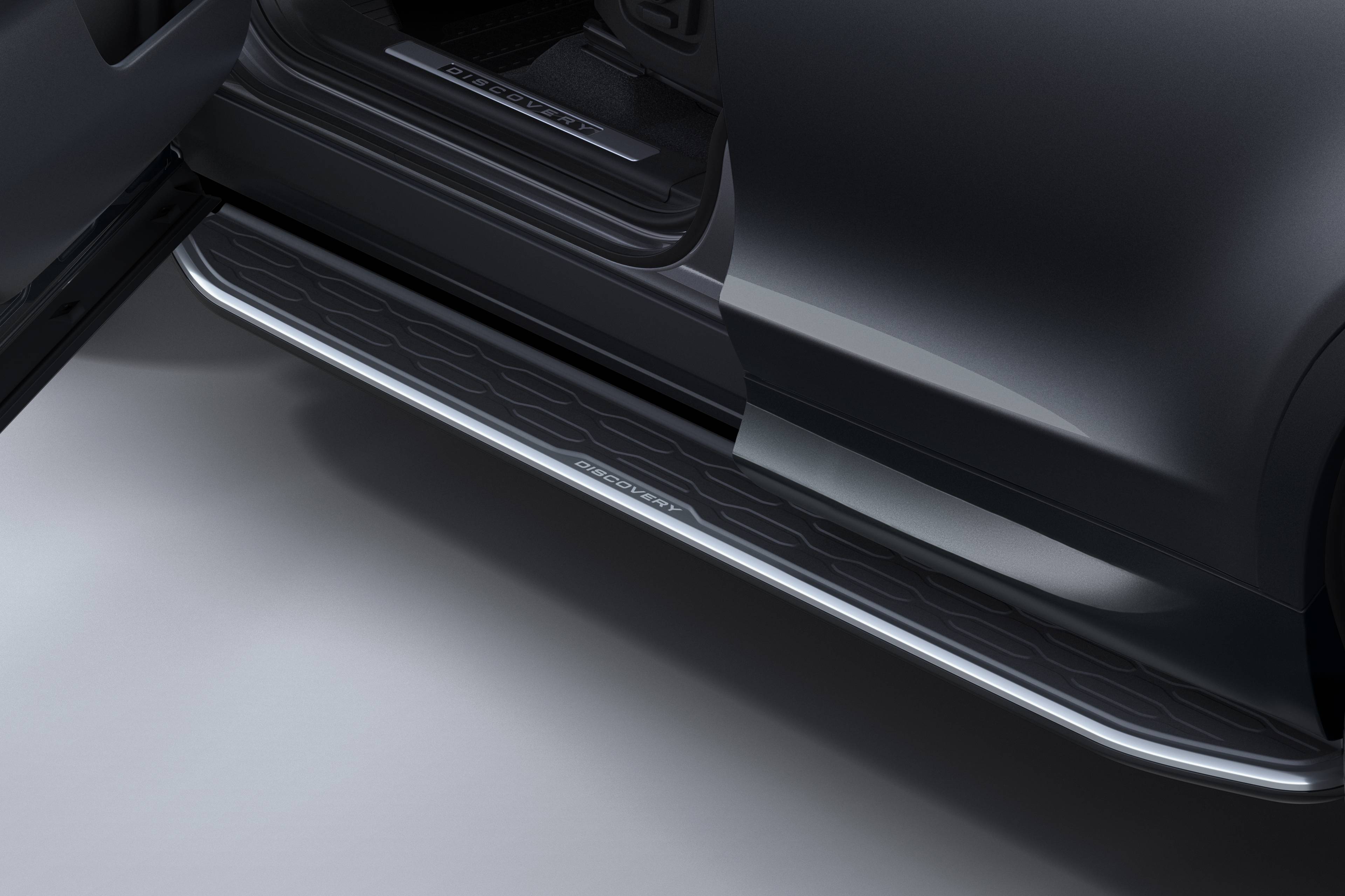 close up of the side of a black discovery sport with bright side tubes