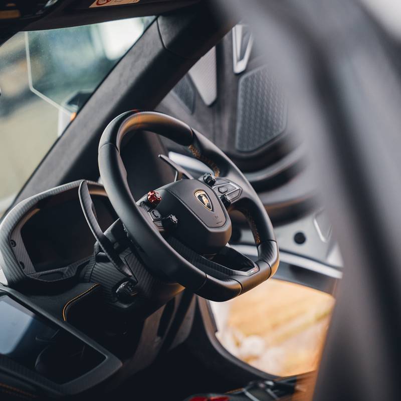 Steering wheel shot of Lamborghini Revuelto in black with orange trims