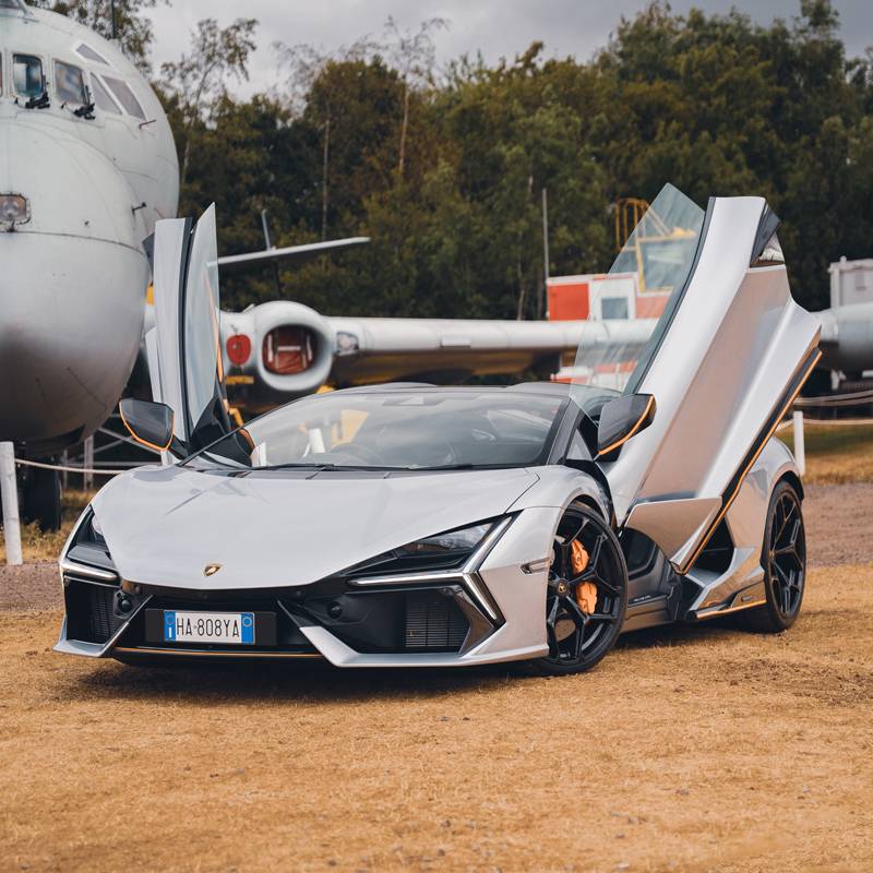 Front of a Lamborghini Revuelto in sliver with orange trims, doors up