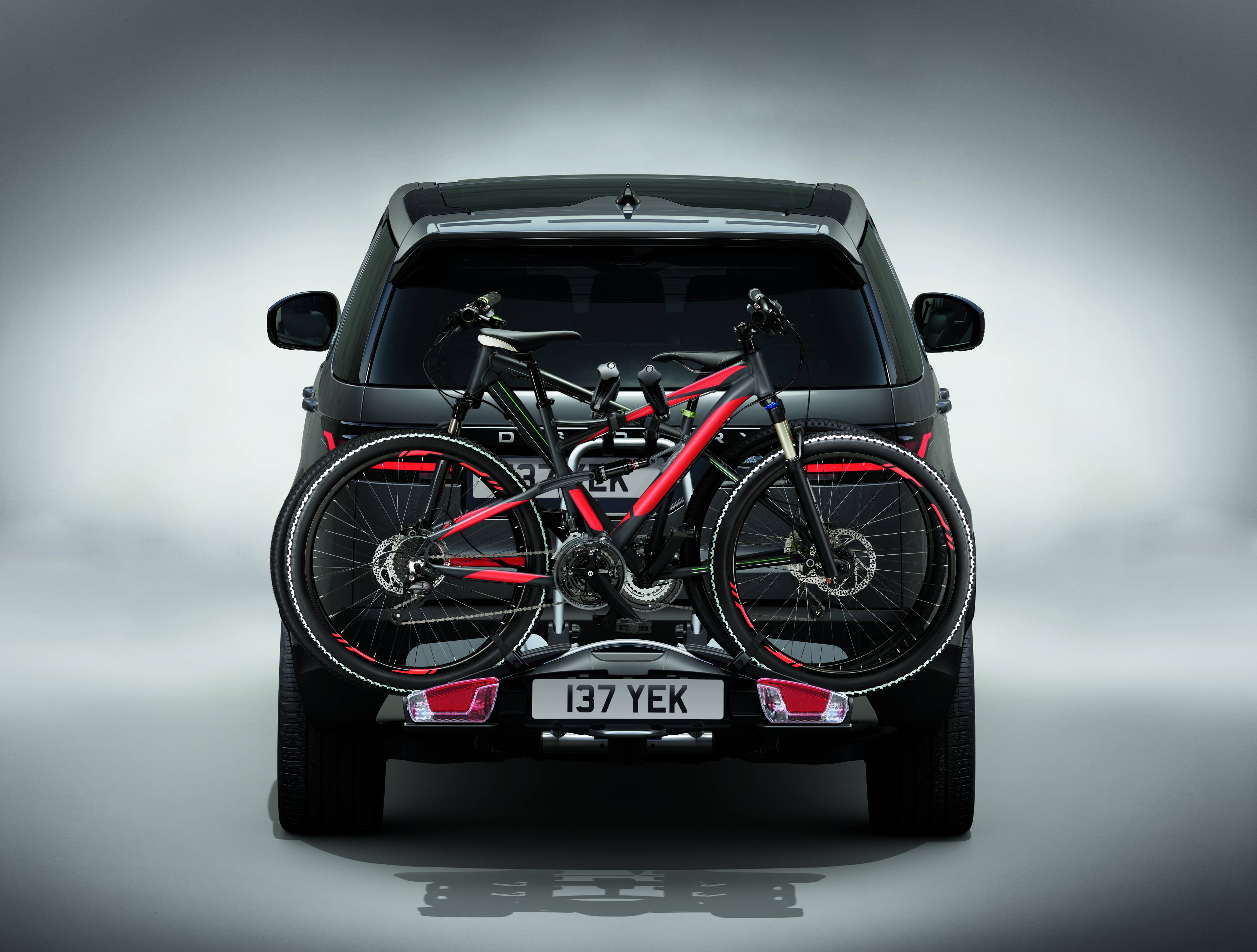 rear view of grey Discovery with a bike attached to the back