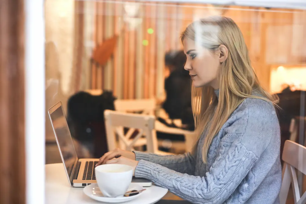 Women in coffee shop working on computer