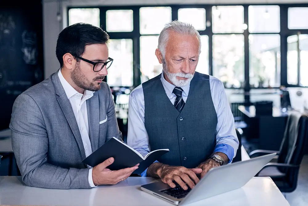 Two men looking at a laptop