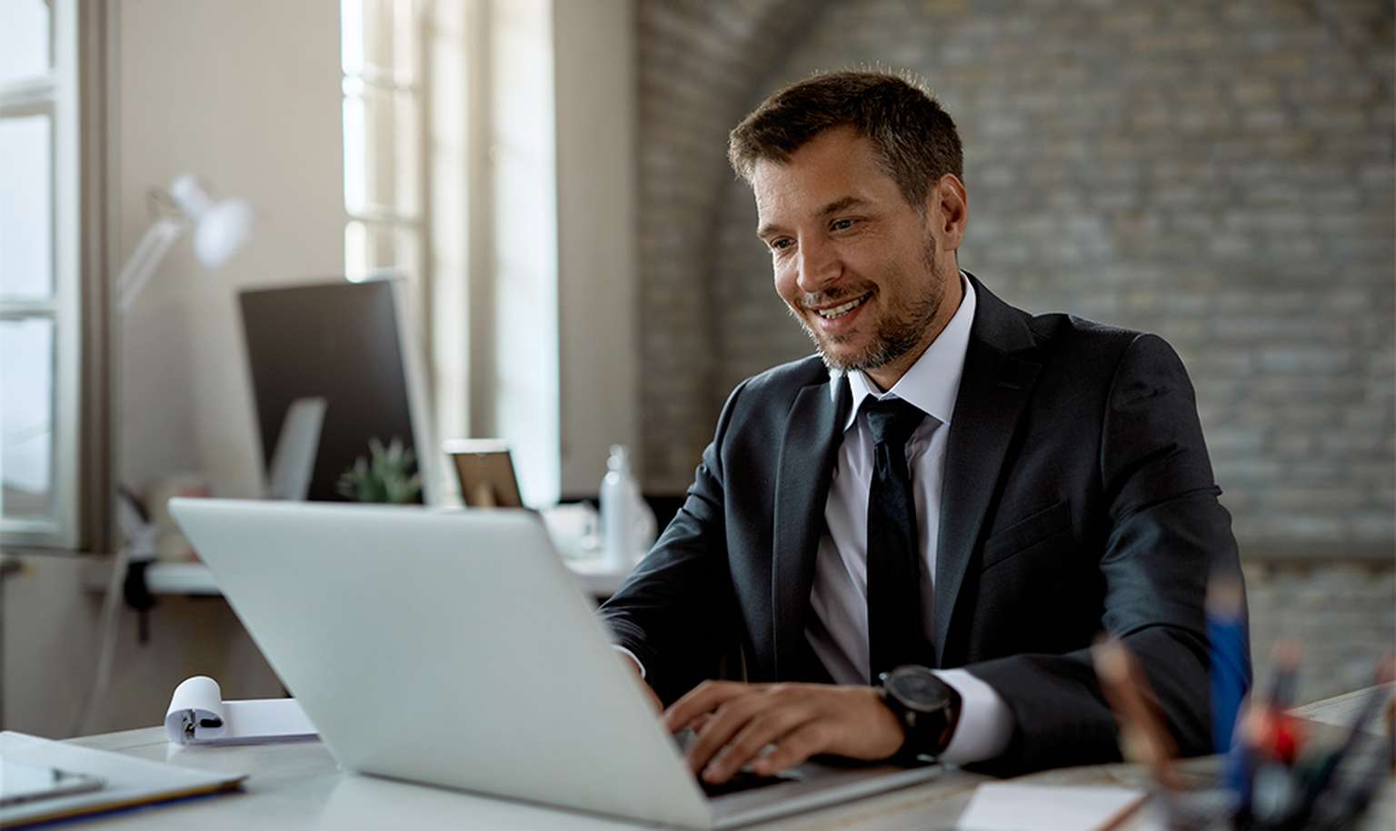 Man smiling and looking at laptop